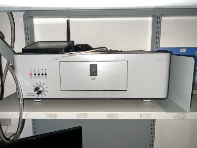 un ordinateur blanc posé sur une étagère, à côté d'un écran