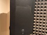 a close up of a speaker on a stand in front of a wall