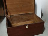 une caisse en bois ouverte, posée à même le sol