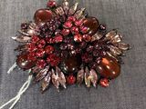 une broche rouge posée sur un tissu bleu