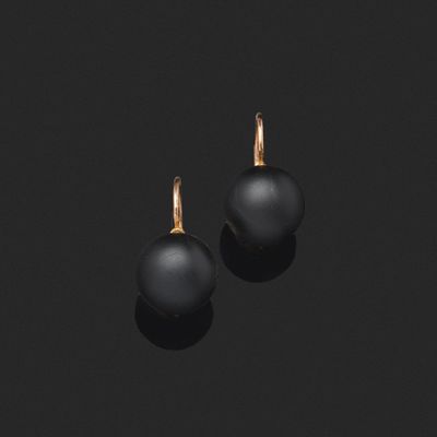 une paire de boucles d'oreilles en perles noires sur fond noir