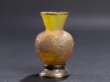un vase jaune posé sur une surface noire