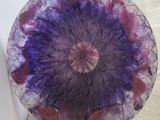 a glass plate with a purple and red flower on it