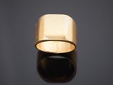 gros plan d'une bague en or sur une surface noire