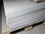 une pile de plaques métalliques posée sur une palette dans un entrepôt