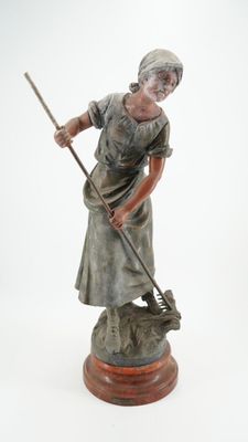 figurine représentant une femme en train de balayer le sol avec un balai