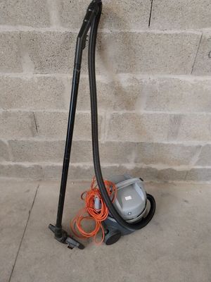 a vacuum that is sitting on the ground next to a brick wall