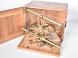 a wooden box with a brass compass inside of it
