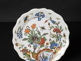 a close up of a plate with flowers and birds on it