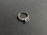 gros plan d'une bague en argent sur une surface noire