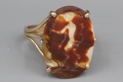 une image d'une bague sertie d'une pierre marron et blanche