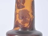 a brown vase with flowers on it on a white surface