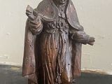 a statue of a man holding a book on a table