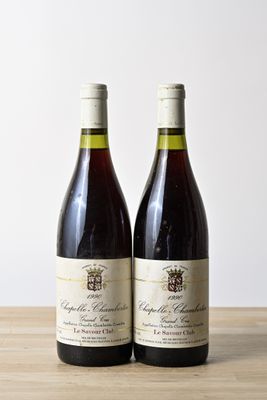 two bottles of wine sitting on top of a wooden table