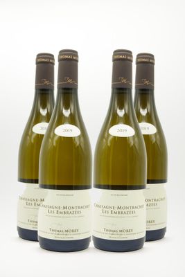 trois bouteilles de vin posées sur une table blanche