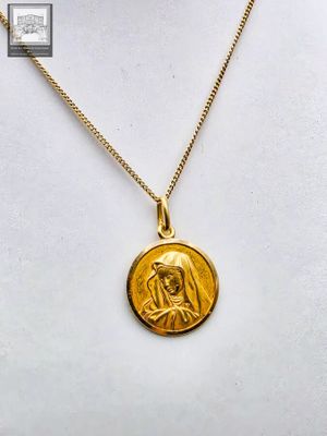 un collier plaqué or orné d'une image de la Vierge Marie