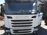 un camion garé sur un terrain avec d'autres camions à l'arrière-plan