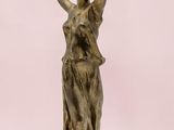 statue en bronze représentant une femme les mains levées vers le ciel