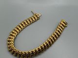 un bracelet en chaîne d'or avec un fermoir sur fond gris