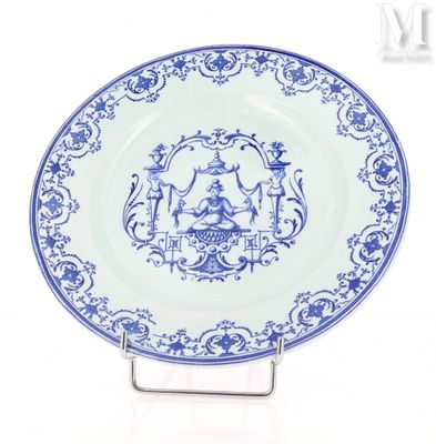 une assiette bleue et blanche sur laquelle est représenté un homme et une femme