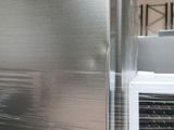 a picture of a stainless steel refrigerator in a warehouse