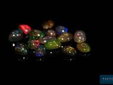 de très jolies perles de verre colorées sur un fond noir