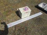 a white box sitting on the ground next to a remote control