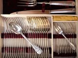 silverware in a wooden box with red linings and spoons