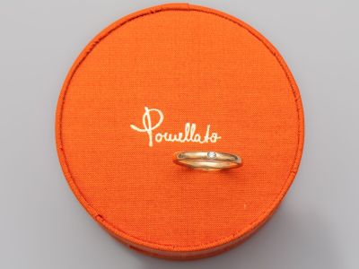 une boîte orange contenant un anneau sur lequel est inscrit le mot « paulloo »
