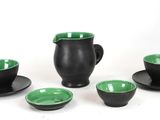 four cups and saucers sitting on a white surface