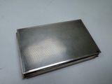 an old silver cigarette case sitting on top of a white table