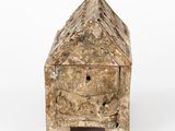 an old wooden box with a face on it on a white surface
