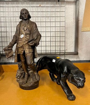 une statue représentant un homme et un chien posée sur une table