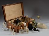 a wooden box filled with bottles of perfume on a white surface