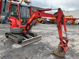a red excavator that is parked in a parking lot