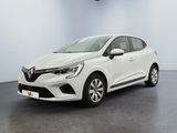 Une voiture blanche est garée dans une pièce au sol noir.