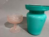 a blue vase and a glass sitting on a table