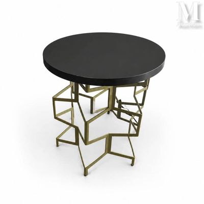 une table noire avec des pieds en métal doré et un plateau noir
