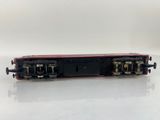a black and red train car sitting on top of a white surface