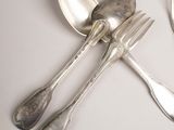 four silver spoons and two silver spoons on a white table