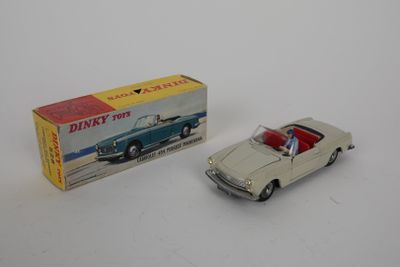 petite maquette de voiture avec une boîte, posée sur une surface blanche