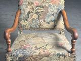 a chair with a floral upholstered back and wooden legs