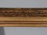 an antique gold framed mirror with a floral design on it