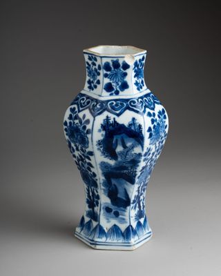 blue and white vase with a bird and flowers on it