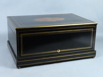 une boîte noire et dorée ornée d'un médaillon doré sur le couvercle