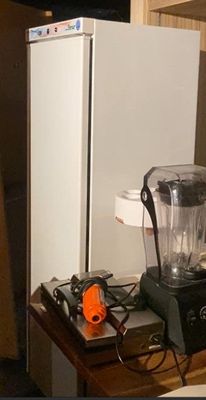 a blender sitting on top of a table next to a refrigerator