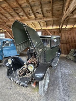 une vieille voiture qui prend la poussière dans un garage