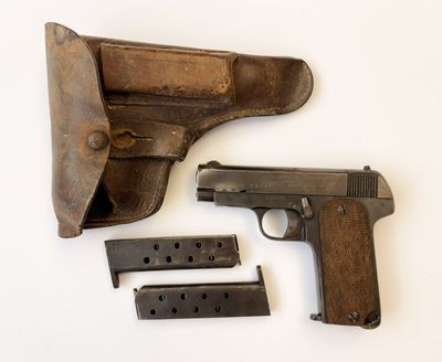 un pistolet et un étui posés sur une surface blanche