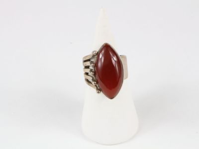 a close up of a ring with a red stone on it
