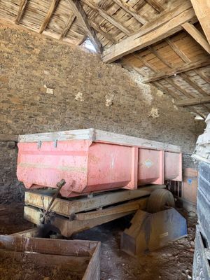 a pink dump truck sitting inside of an old barn